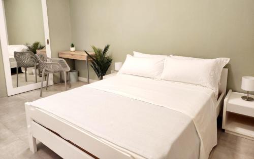 a white bed in a room with a table and chairs at The Beach Life Pereybere in Pereybere