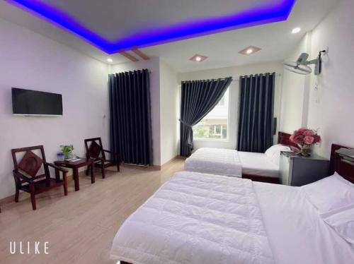 a bedroom with two beds and a purple ceiling at Hotel Phương Anh in Phù Cát