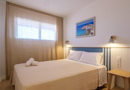 a bedroom with a white bed with a window at Áncora Salou La Siesta Apartments in Salou