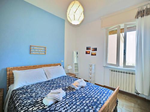 Un dormitorio azul con una cama con toallas. en Cà Sea, en San Terenzo
