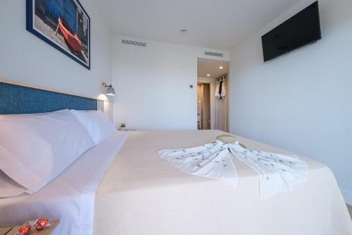 a bedroom with a white bed with a tv on the wall at Áncora Salou La Siesta Apartments in Salou