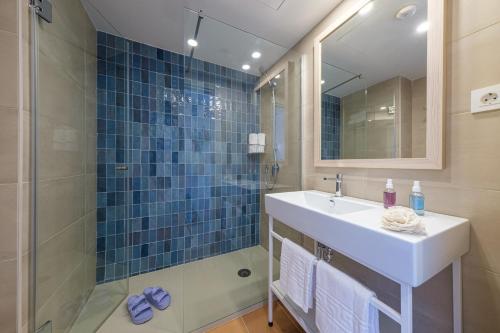 a bathroom with a sink and a shower with a mirror at Áncora Salou La Siesta Apartments in Salou
