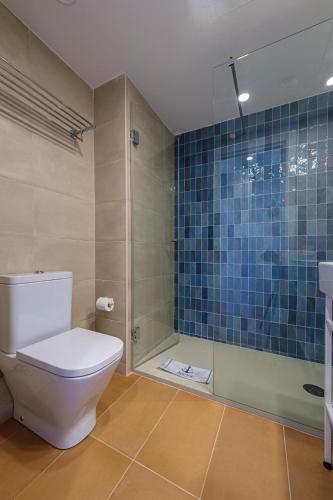a bathroom with a toilet and a glass shower at Áncora Salou La Siesta Apartments in Salou