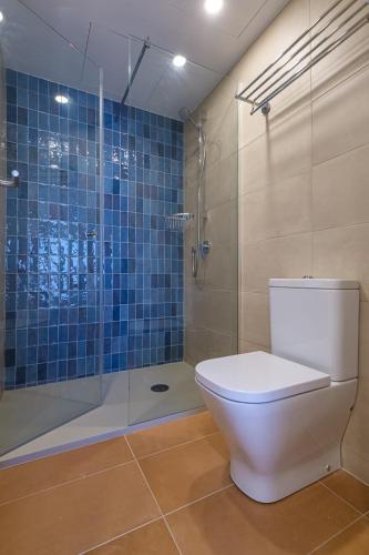 a bathroom with a toilet and a glass shower at Áncora Salou La Siesta Apartments in Salou