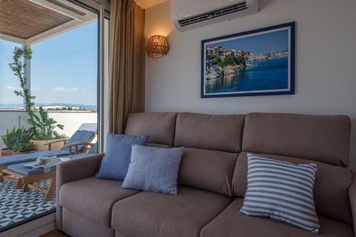 a couch in a living room with a view of the ocean at Áncora Salou La Siesta Apartments in Salou