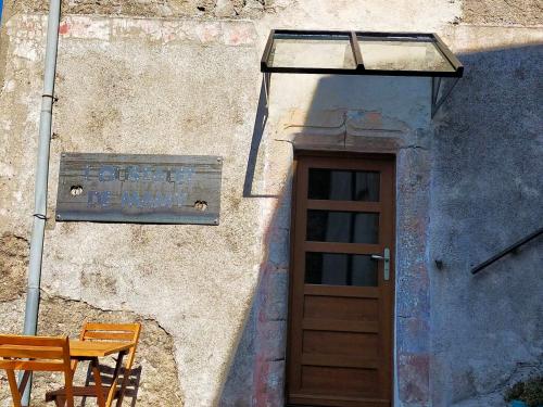 a door to a building with a table and a bench at L'oustalet de Mamy in Dourbies