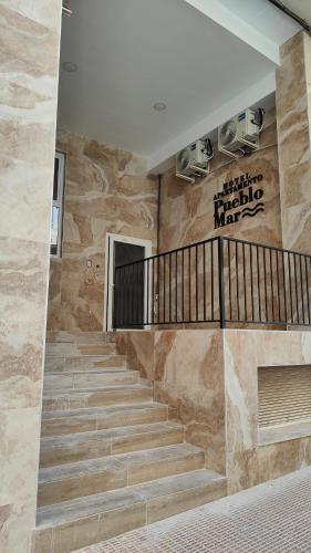 a staircase in a building with a stone wall at Apartamentos Pueblo Mar in Calpe