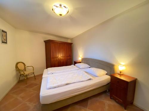 un dormitorio con una cama con una mesita de noche y dos lámparas en Callantsoger Staete A107, en Callantsoog