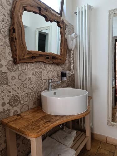 a bathroom with a white sink and a mirror at La Cummersa fra i Trulli in Alberobello