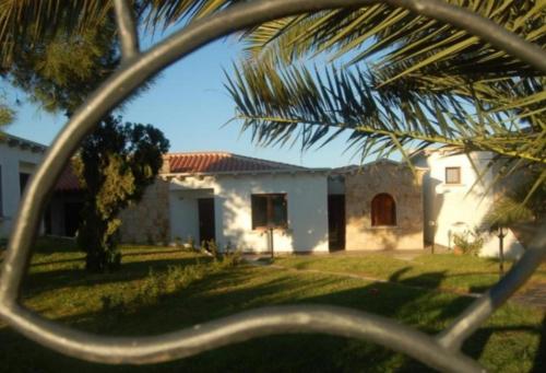 a view of a house through a palm tree at Relax al Mare in Olbia