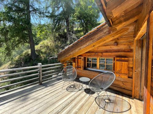 two chairs on the deck of a cabin at Chalet Ourson Brun by Mrs Miggins in Grimentz