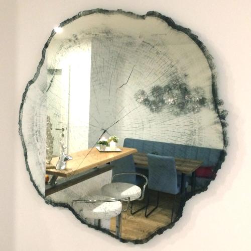 un miroir suspendu au mur avec une table et des chaises dans l'établissement Ferienwohnung Schwan, à Bad Reichenhall