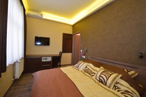 a bedroom with a bed and a desk and a television at Fig Tree House in Budapest