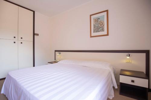 a bedroom with a white bed and a black night stand at Hotel Fabricia in Portoferraio
