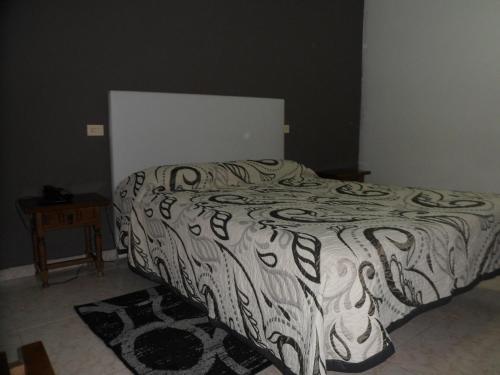 a bedroom with a bed with a black and white comforter at Hotel Conde in Taboadela