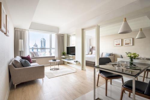 a living room with a dining table and a living room with a bed at Two MacDonnell Road in Hong Kong