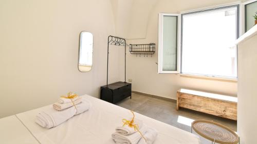 a white room with a table and a window at Les Maisons Casetta del Vico by Rentbeat in Sannicola