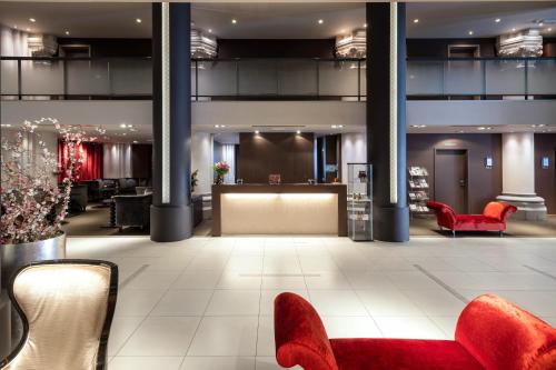 a lobby with red chairs and a waiting room at Martin's Patershof in Mechelen