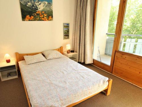 a bedroom with a bed and a large window at Appartement cosy avec piscine à 60m des pistes – 5 pers, parking privé, La Salle-les-Alpes. - FR-1-330F-73 in Serre Chevalier