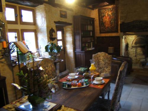 ein Esszimmer mit einem Tisch mit Essen darauf in der Unterkunft Domaine des 3 vallee dordogne in Salignac Eyvigues