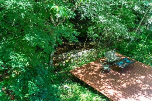 an overhead view of a table and chairs on a wooden deck at 深山山荘 DENCHI in Uchiko