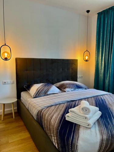 a bedroom with a bed with two towels on it at Alexander Cozy Apartment FREE PRIVATE PARKING in Mediaş
