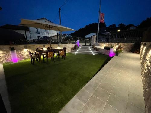 a patio with a table with chairs and an umbrella at Casa El Pendo in Escobedo