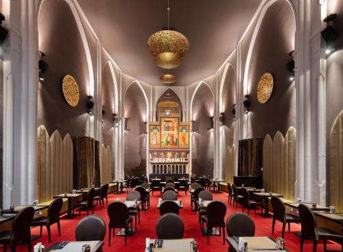 - une salle à manger dans une église avec des tables et des chaises dans l'établissement Martin's Patershof, à Malines