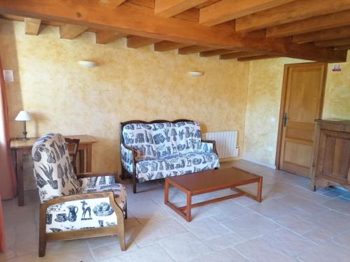 a living room with a chair and a coffee table at Logis de Flamenac in Pranzac