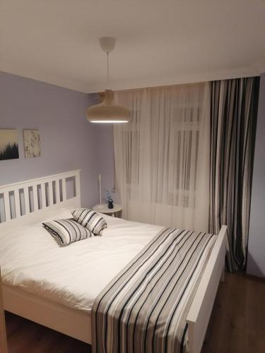1 dormitorio con 1 cama blanca grande y 2 almohadas en House KA Naz en Çanakkale