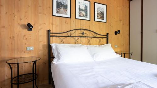 a bedroom with a white bed and a table at Italianway - San Gallo 16 in Bormio