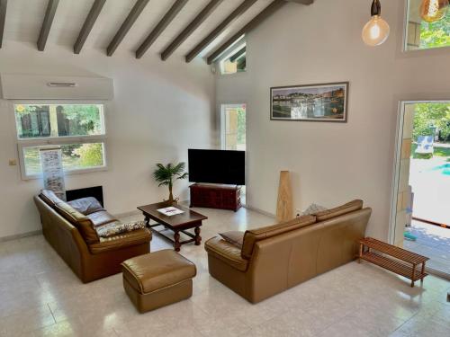 a living room with two couches and a tv at Belle Villa basque avec piscine et jardin de 3000m2 in Saint-Jean-de-Luz