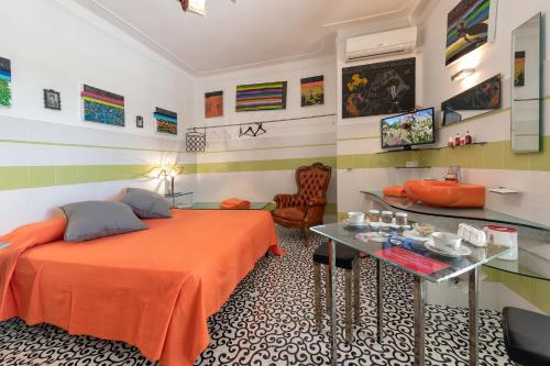 1 dormitorio con cama de color naranja y mesa en Casa D'Artista - Le stanze della stupidità, en Borgagne