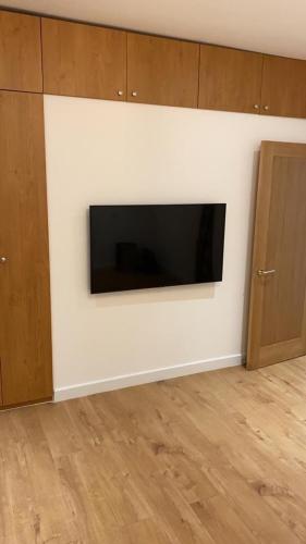 un soggiorno con TV a schermo piatto a parete di Newly refurbished flat in camberwell, london a Londra