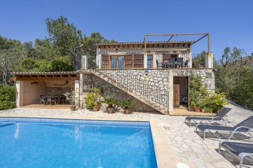 a villa with a swimming pool and a house at Es Puchet in Búger