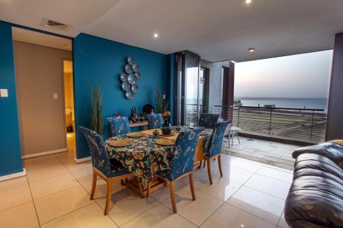 uma sala de jantar com uma mesa e cadeiras com vista para o oceano em Stay at The Point - Kaleidoscopic Caribbean Cruise em Durban