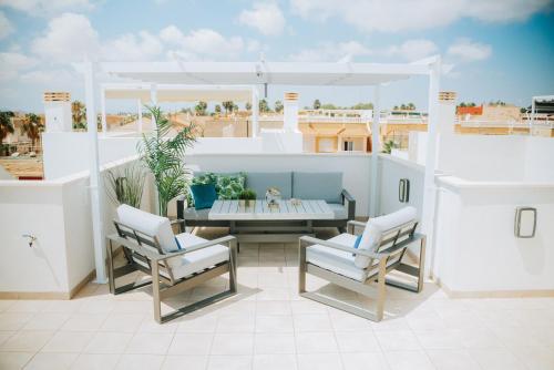 Un patio con una mesa y sillas en un balcón. en Villa Happy Moments, en Los Alcázares