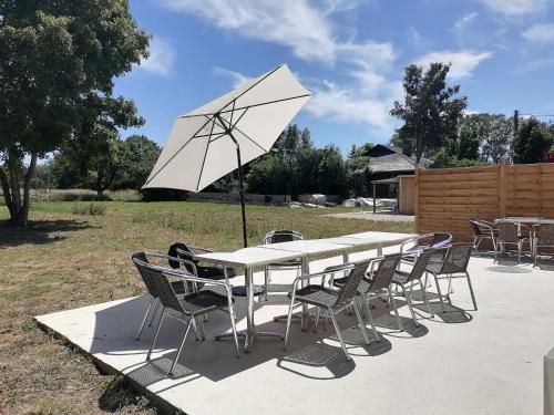 a white table and chairs with a white umbrella at Manoir en Pierre Chartres in Chartres