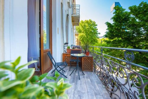 porche con mesa y sillas en el balcón en Rustaveli Hotel, en Tiflis