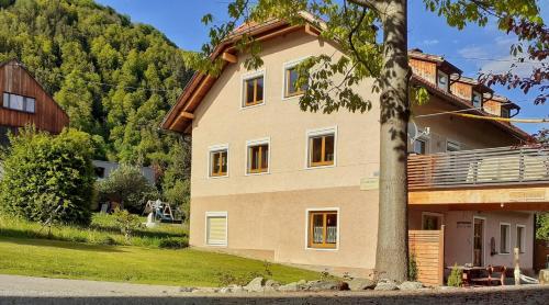 a house with a mountain in the background at Apartment Fischer mit Privatstrand in Steindorf am Ossiacher See