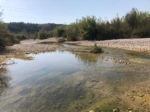 a body of water with rocks and trees at Casa Rural El Corral del Tío Santiago in Mazaleón