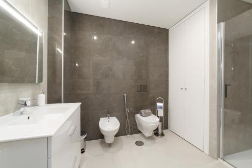 a bathroom with a toilet and a sink and a shower at Nazaré Views X - By SCH in Nazaré