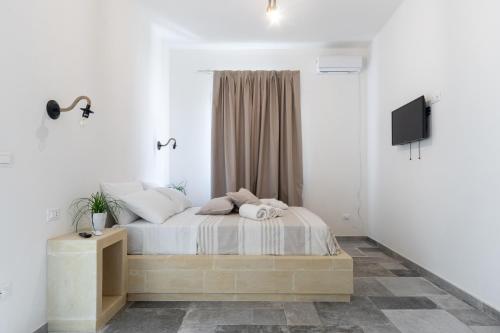 a bedroom with a bed and a tv on a wall at Villa Franitu - Corsano in Corsano