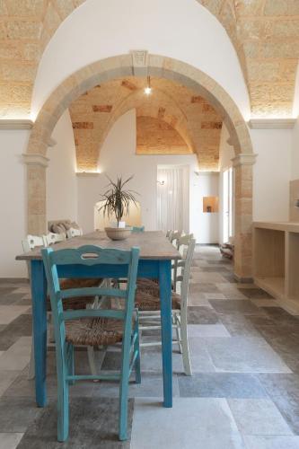 a dining room with a blue table and chairs at Villa Franitu - Corsano in Corsano