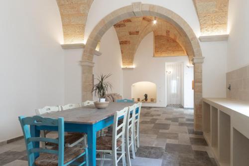 a kitchen and dining room with a blue table and chairs at Villa Franitu - Corsano in Corsano