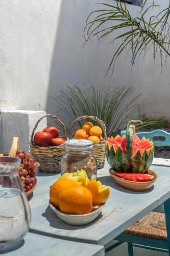 a table topped with plates of fruit and baskets of fruits at Villa Franitu - Corsano in Corsano