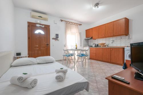 a room with a bed and a kitchen with a tv at A & K Vacation House in Varos