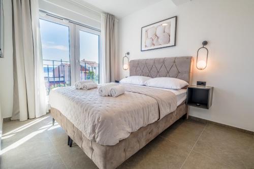 een slaapkamer met een groot bed en een groot raam bij Apartment House Vista in Crikvenica