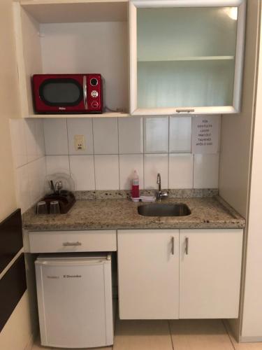 a small kitchen with a sink and a microwave at Studio 01 Modelo Flat in Salvador