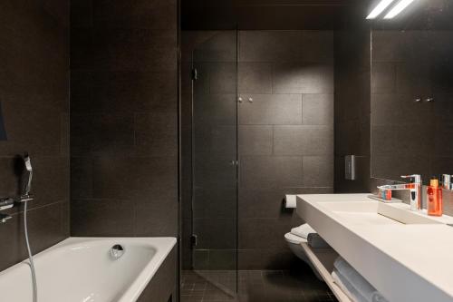 a bathroom with two sinks and a bath tub at Solo Sokos Hotel Torni Tampere in Tampere